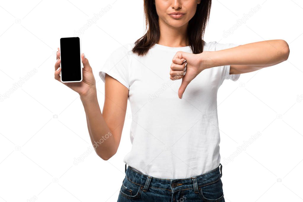 cropped view of woman showing thumb down and smartphone with blank screen, isolated on white