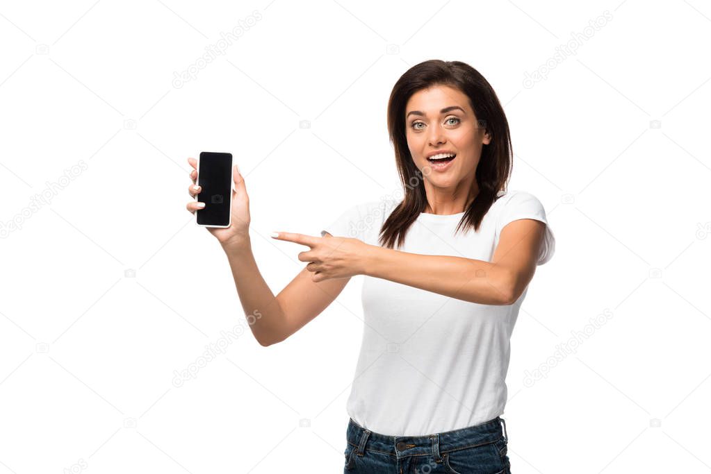 excited woman pointing at smartphone with blank screen, isolated on white