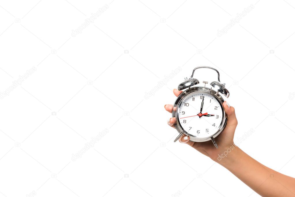 partial view of woman holding alarm clock, isolated on white