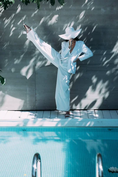 白いスーツの大人の女性と外でポーズをとる帽子 — ストック写真