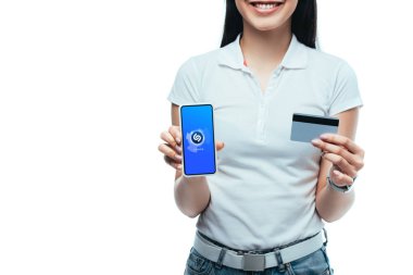 Kyiv, Ukrayna - 15 Temmuz 2019: elinde shazam uygulaması olan gülümseyen esmer Asyalı kız, elinde kredi kartı ve akıllı telefon tutuyordu.