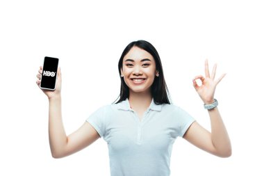Kyiv, Ukrayna - 15 Temmuz 2019: mutlu esmer Asyalı kadın Hbo uygulaması ile akıllı telefon tutuyor ve beyaz üzerinde 