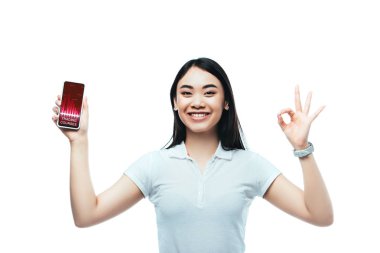Mutlu esmer Asyalı kadın akıllı telefonu ticaret kursları uygulaması ile tutuyor ve beyaz üzerinde 