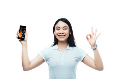Mutlu esmer Asyalı kadın iş uygulamalı akıllı telefonu tutuyor ve beyaz üzerinde 