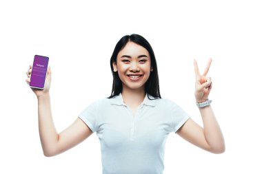 Kyiv, Ukrayna - 15 Temmuz 2019: Instagram uygulaması ile akıllı telefon tutan mutlu esmer kadın ve beyaz üzerinde barış işareti gösteriyor