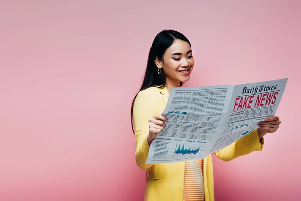 Ευτυχισμένη Ασιάτισσα Κίτρινη Στολή Που Διαβάζει Εφημερίδα Ψεύτικα Νέα Απομονωμένα — Φωτογραφία Αρχείου