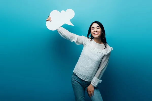 Sonriente Morena Asiático Mujer Holding Blanco Pensamiento Burbuja Azul Fondo —  Fotos de Stock