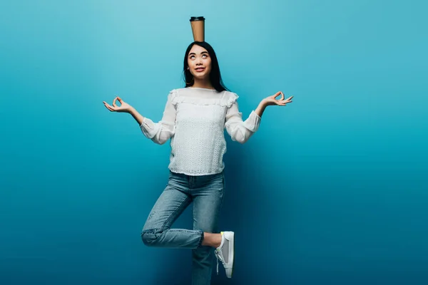 Smiling Brunette Asian Woman Meditating Coffee Head Blue Background — Stock Photo, Image