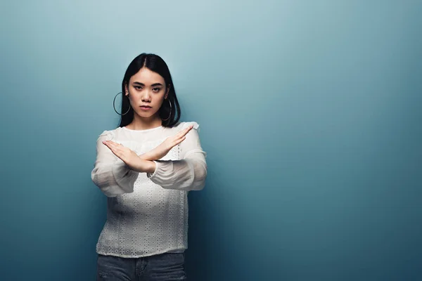 Boos Brunette Aziatische Vrouw Tonen Stop Gebaar Blauwe Achtergrond — Stockfoto