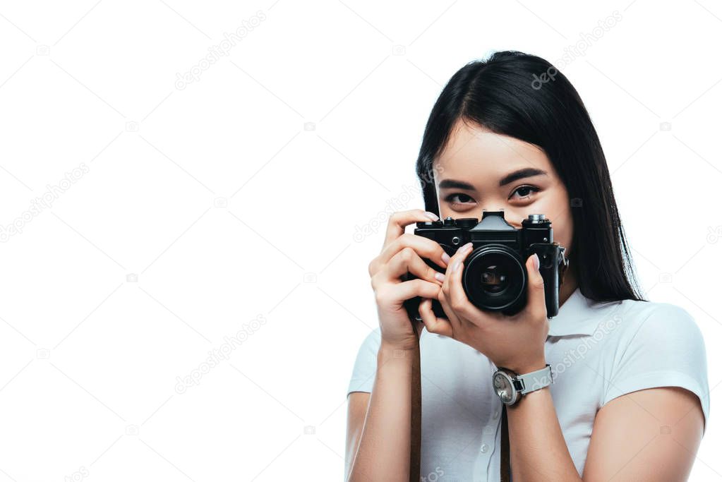 brunette asian woman taking picture on digital camera isolated on white