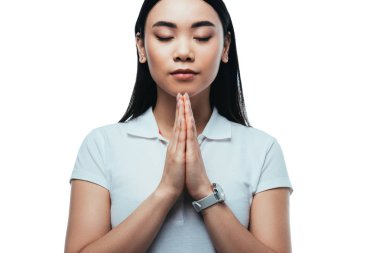 attractive asian girl with closed eyes and praying hands isolated on white clipart