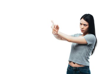 displeased asian girl showing stop gesture isolated on white