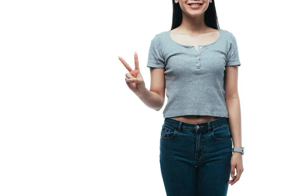 白に隔離された平和の印を示す魅力的なアジアの少女の笑顔のクロップドビュー — ストック写真