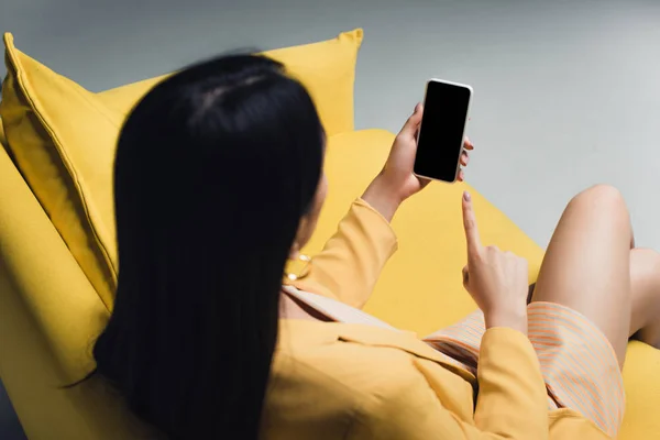 Morena Empresaria Sentada Sofá Amarillo Apuntando Con Dedo Smartphone Con — Foto de Stock