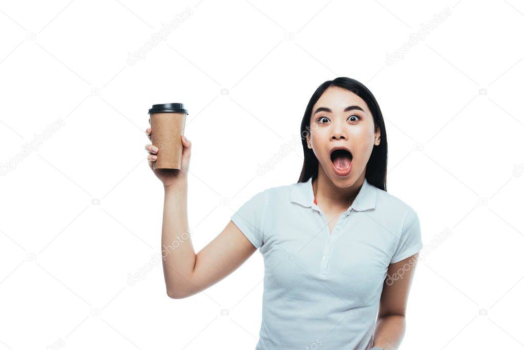 shocked attractive asian girl with open mouth holding paper cup isolated on white