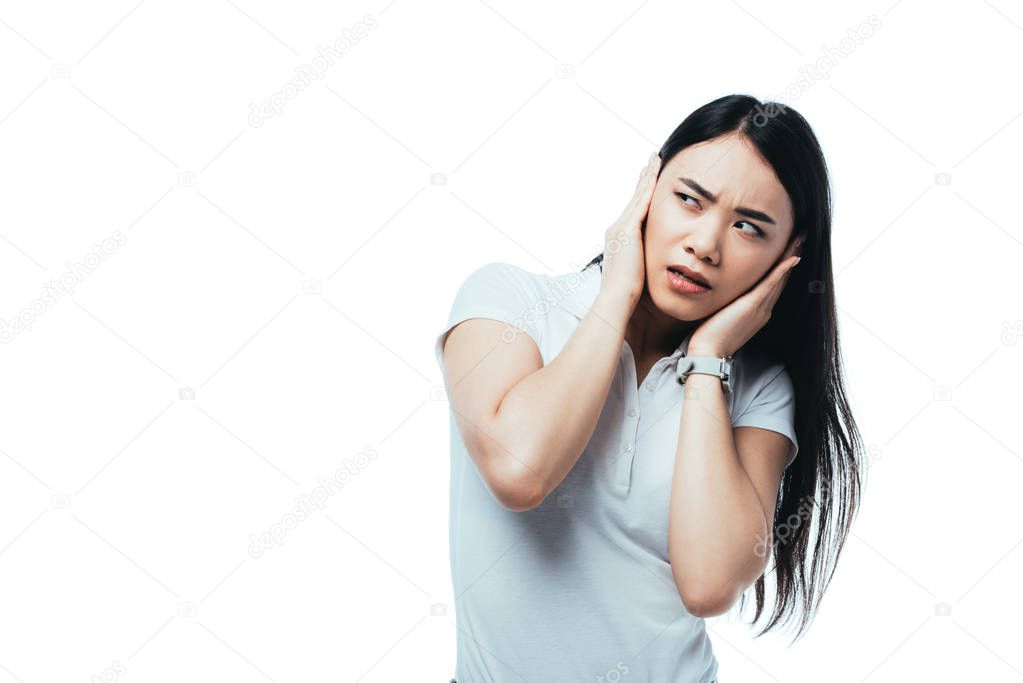 confused attractive asian girl covering ears with hands isolated on white