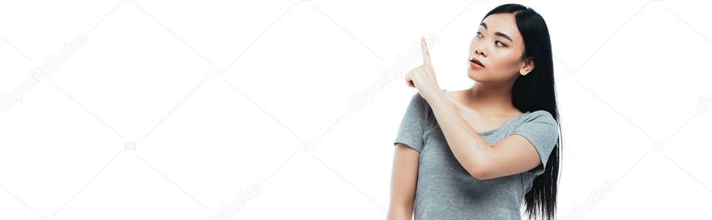 asian girl pointing with finger aside isolated on white, panoramic shot