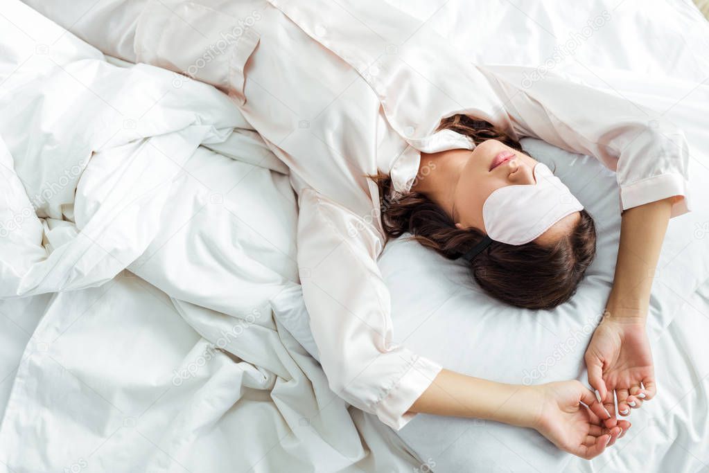 top view of woman in sleeping mask lying in bed at morning 