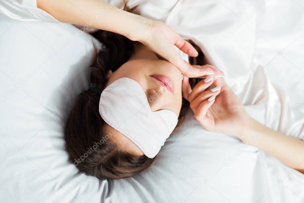 high angle view of woman in sleeping mask lying in bed at morning 