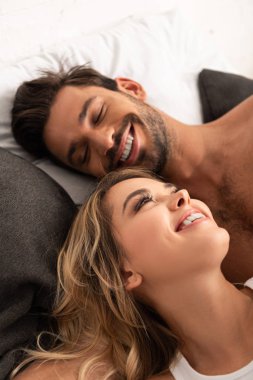 Güzel, gülümseyen bir çift sabahları yatakta yatıyor. 