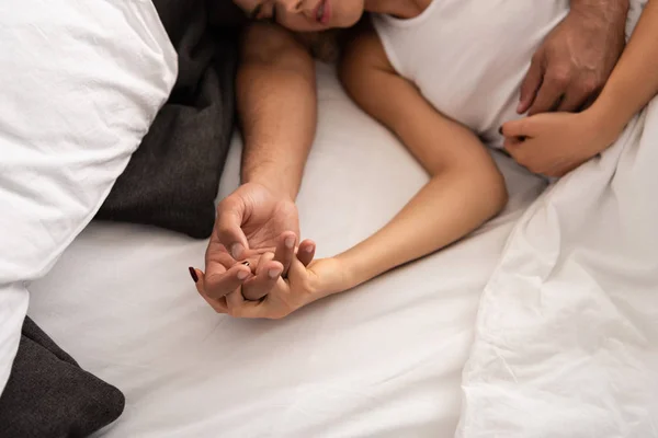 早上睡觉的夫妻手牵着手在床上拥抱 — 图库照片
