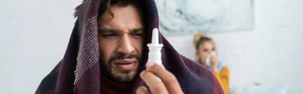 Homem Doente Segurando Spray Nasal Quarto Com Mulher Atrás — Fotografia de Stock