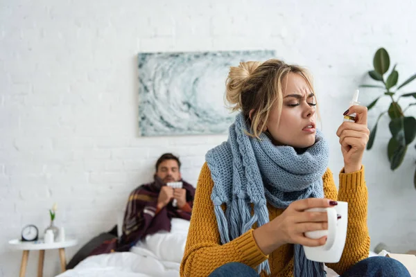 Mujer Enferma Sosteniendo Aerosol Nasal Bebida Caliente Dormitorio Con Hombre — Foto de Stock