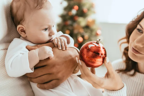 Vista Recortada Madre Feliz Dando Bola Navidad Lindo Bebé Sentado — Foto de Stock