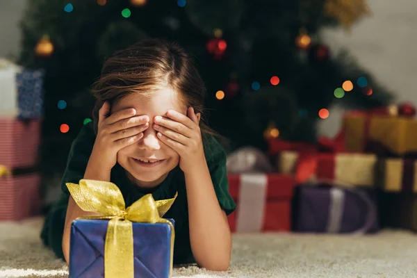 Smiling Kid Lying Floor Gift Box Covering Eyes Hands — Stock Photo, Image