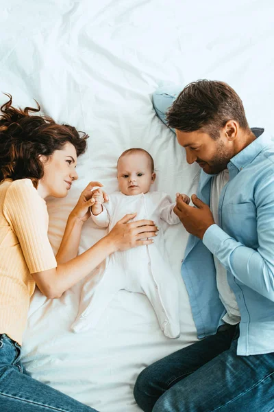 Padres Felices Tocando Suavemente Adorable Bebé Mientras Yacen Juntos Cama —  Fotos de Stock