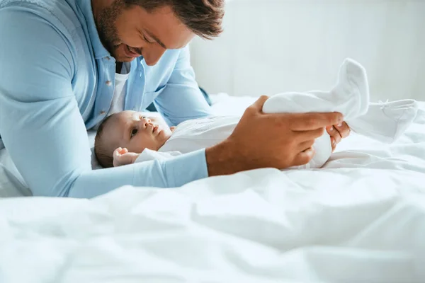 Happy Father Touching Legs Cute Little Daughter Lying White Bedding — Stock Photo, Image