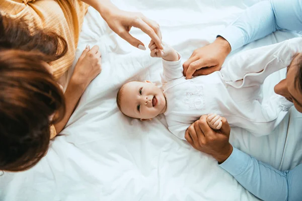 Vista Superior Dos Pais Tocando Bebê Sorridente Deitado Cama Branca — Fotografia de Stock