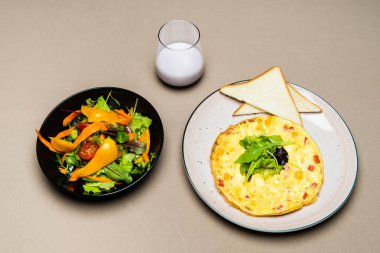  salad, omelet, toasts and yogurt in glass on table 