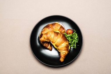 top view of croissants in black plate on table for breakfast clipart