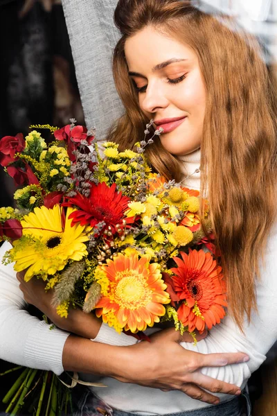 魅力的な笑顔の赤い頭の女性窓の近くに秋の花の花束 — ストック写真