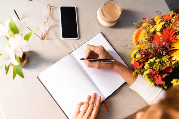 Vista Recortada Mujer Escribiendo Bloc Notas Cafetería Con Café Teléfono — Foto de Stock