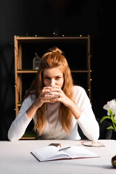 Kafede Elinde Defteriyle Bir Bardak Kahve Tutan Düşünceli Bir Kadın — Stok fotoğraf