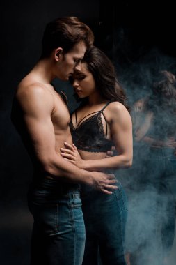 Güzel, genç, seksi çift aynanın yanında sarılıyor.