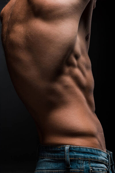 partial view of shirtless male torso isolated on black