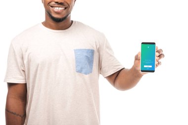 Kyiv, Ukrayna - 15 Ağustos 2019: Twitter uygulamalı akıllı telefonu olan gülümseyen Afro-Amerikan bir adamın kısmi görüntüsü beyaz ekranda izole edildi.