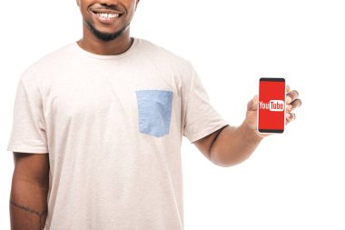 Kyiv, Ukrayna - 15 Ağustos 2019: Youtube uygulaması ile akıllı telefon tutan gülümseyen Afrikalı Amerikalı adamın kısmi görüntüsü beyaz ekranda izole edildi.