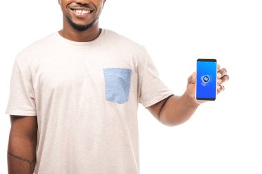 Kyiv, Ukrayna - 15 Ağustos 2019: Beyaz ekranda Shazam uygulaması ile akıllı telefon tutan gülümseyen Afrikalı Amerikalı adamın kısmi görüntüsü.