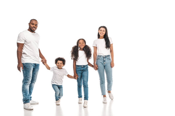 happy african american parents holding hands with daughter and son while standing on white background