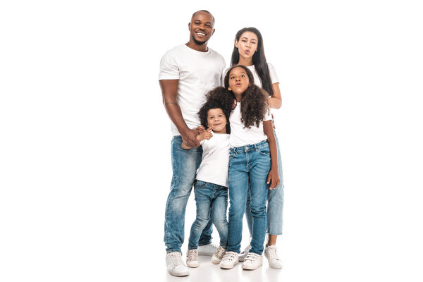 Веселые африканские мать и дочь делают утки лица, стоя рядом с отцом и сыном на белом фоне
