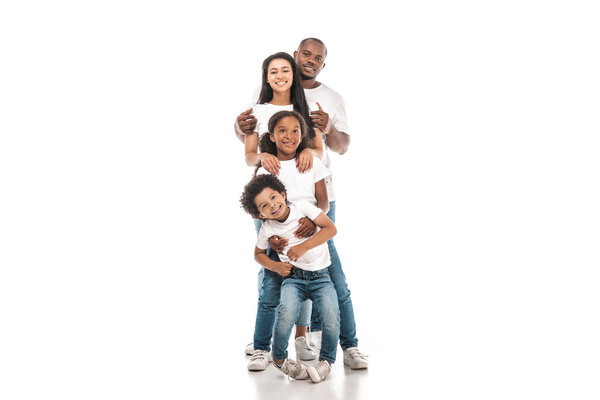 cheerful african american family standing one behind other and smiling at camera on white background