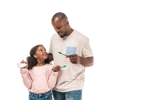歯ブラシと歯磨き粉を持ったアフリカ系アメリカ人の子供が白い歯ブラシで父親を見て — ストック写真