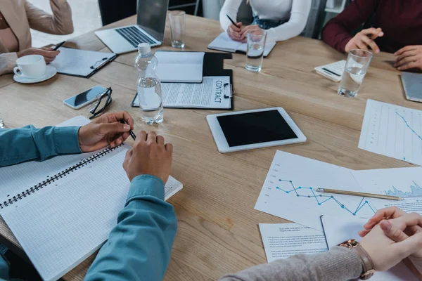 Vista Recortada Los Empresarios Sentados Escritorio Cerca Dispositivos Digitales Cuadernos — Foto de Stock