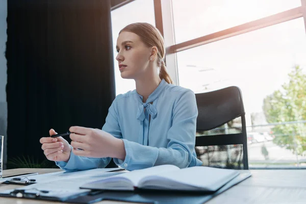 Junge Konzentrierte Geschäftsfrau Hält Stift Der Hand Während Sie Schreibtisch — Stockfoto