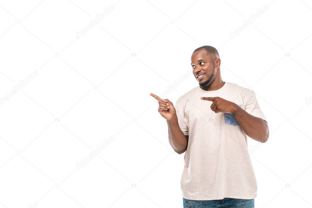 cheerful african american man looking away and pointing with fingers isolated on white