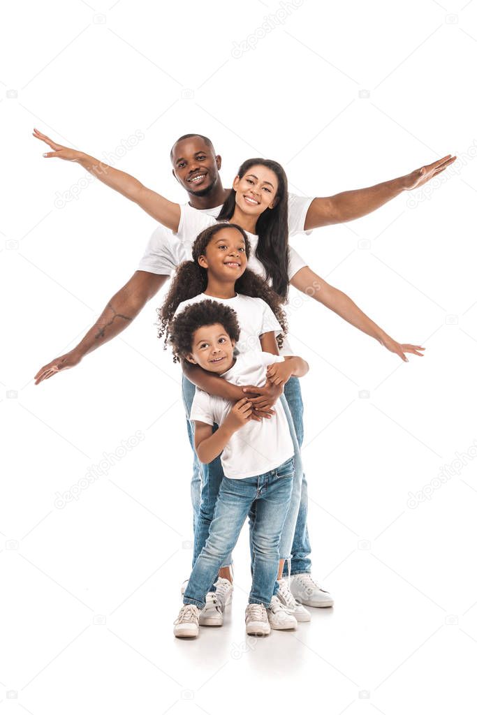 cute african american child hugging brother while cheerful parents imitating flight on white background
